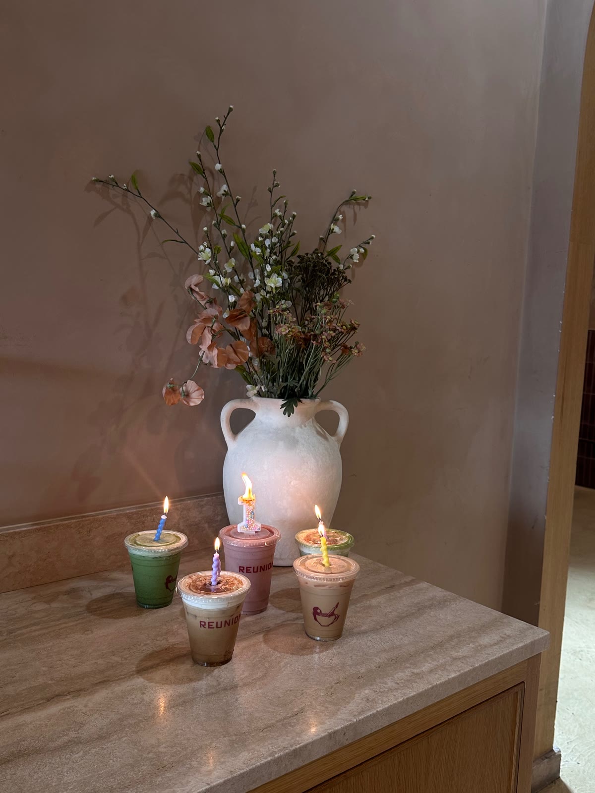 Candlelit Reunion drinks on the counter beneath a vase of flowers
