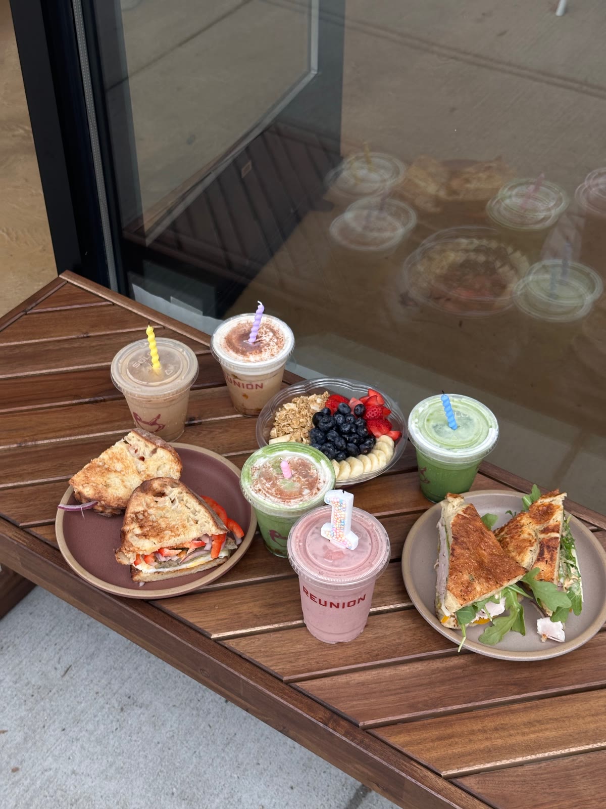Reunion drinks with candles, sandwiches and a fruit bowl on an outdoor table